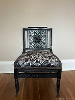 Front view of the carved antique chair showing the detailed backrest and upholstered seat.