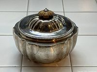 Front view of scalloped bowl with domed lid and wood knob