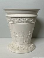 Front view of vase showing classical figure relief and grapevine garland