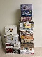 Stack of boxed items including glass canning jars, tissue boxes, and wine glass sets
