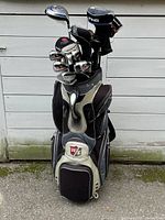 Full view of Wilson Staff bag loaded with clubs against white wall
