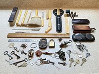 Entire collection laid out including brushes, keys, thimbles, locks, grooming tools, ruler, scissors, glasses.