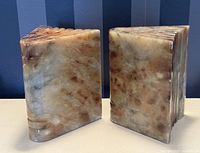 Side view of pair of carved onyx bookends showing natural stone pattern and shape