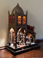 Front three-quarter view showing domed top, arched windows with colored glass and base platform