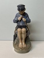 Front view of the Royal Copenhagen porcelain figurine showing the boy in cap and detailed facial features.