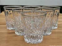 Front view of six Thomas Webb crystal Scotch tumblers arranged in two rows on a wooden surface.