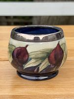 Front view showing hand-painted fig motif and silver-plated rim