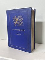 Blue hardcover book with gold embossed title and emblem on front cover.