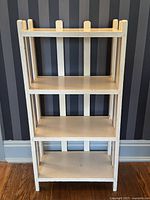 Front view showing all four shelves and raised vertical posts along top edge.