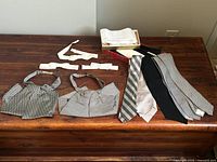 Full lot arranged on wooden table showing neckties, ascots, and bow ties