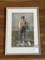 Framed watercolour painting of a young man standing outdoors holding a pipe in his mouth.