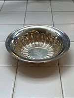 Top view of round fluted sterling silver bowl on white tile