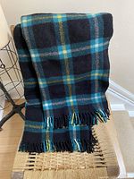 Full view of wool plaid blanket draped on chair