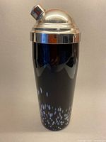 Full view of cocktail shaker showing glass body and metal lid