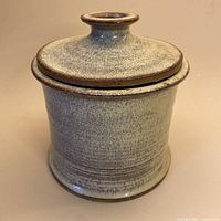 Full view of cylindrical stoneware vessel with lid