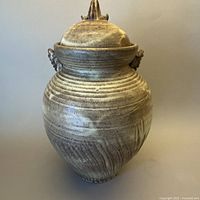 Full view of signed studio pottery lidded urn with lid in place