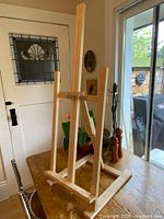 Front view of wooden adjustable folding table easel on table