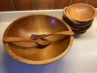 Large Baribocraft maple bowl with fork and spoon inside, stack of side bowls visible