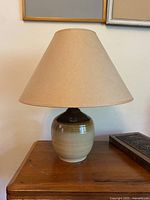 Full view of ceramic lamp with shade on table