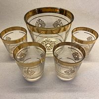 Ice bucket centered with four matching lowball glasses surrounding
