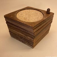 Stacked teak coasters on stand showing overall form