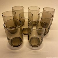 Eight smoky grey tumblers grouped, showing color and size