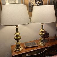 Both brass lamps with shades on tabletop