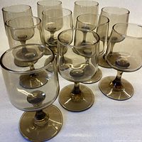Group shot of ten smoky brown stemmed wine glasses