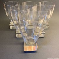 Front view of six crystal goblets showing square bases