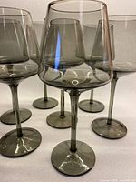 six of the eight smoky grey wine glasses showing bowl shape and stem