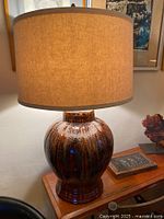 Lamp with tan shade on wooden table