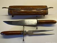 Knife, fork, and carved hardwood case displayed separately