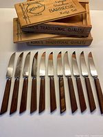 Full set of 12 knives displayed below two branded wooden boxes
