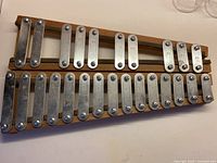 Full view of wooden xylophone with two rows of metal bars