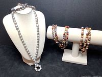 Five pieces including grey pearl necklace and bracelets shown on stands to display length and design