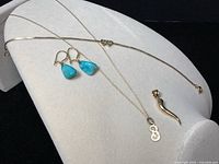 Overview of all five pieces laid on display: chain, two pendants, bracelet, earrings