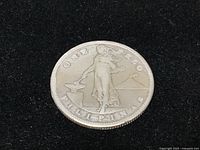 Obverse side of the 1909 S silver coin with 'ONE PESO PILIPINAS' text and standing woman image.