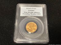 Plastic slab front showing coin and top label “20 Swiss Franc Genuine True Wealth Alliance Founding Member 2005.”
