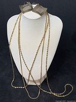 Earrings and all three chains displayed together on bust form.