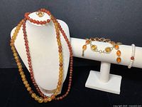 All necklaces and bracelets displayed on bust and T-bar stand