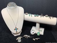Photo of entire jewelry lot showing necklace with turquoise and coral cross pendant, brooches, rings, and earrings with various stones and designs