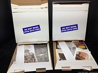 Two mailers containing coins, stamps, and ephemera in protective envelopes with 'Do Not Bend Open With Care' labels visible.