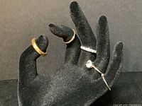 Five rings displayed together on black hand stand