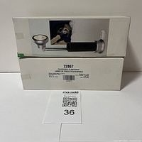 Photo of two white boxes stacked, showing packaging for two new telescopic flashlights, model 22867, sealed and labelled with barcodes and product number.