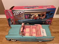 Barbie '57 Chevy convertible car in blue with pink interior, showing wear and seatbelt missing, alongside original box