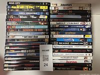 Photo showing 40 DVD movies stacked horizontally in two columns, titles visible on spines.