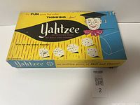 Top view of the vintage Yahtzee game box lid featuring colorful graphics and dice illustrations