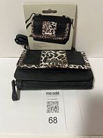 Front view of Jessica Simpson wallet purse with leopard print accents and wrist strap alongside original packaging showing image of the wallet.