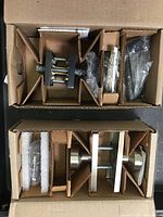 Top view of Baldwin Reserve passage tube door knob set in partitioned cardboard box with all components and hardware packed.