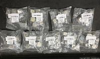 Ten clear plastic bags each containing several satin nickel cabinet knobs with white labels.